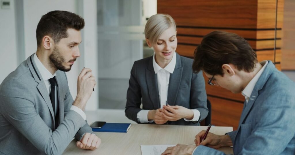 Business people signing a contract at a table