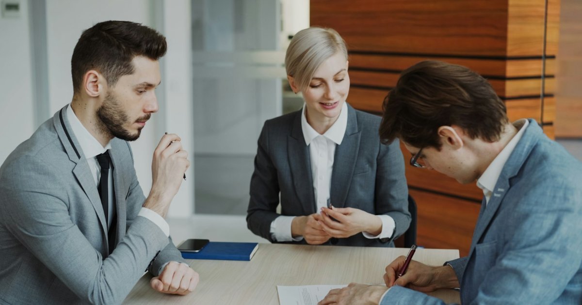 Business people signing a contract at a table